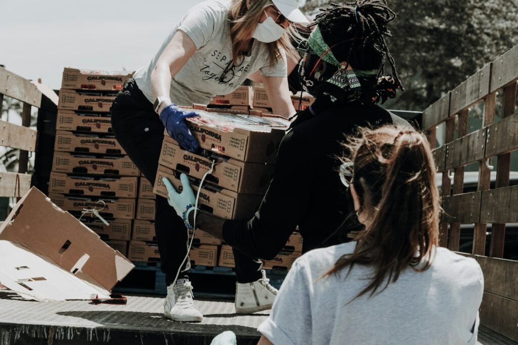Volunteer sitting among donation boxes at a food drive