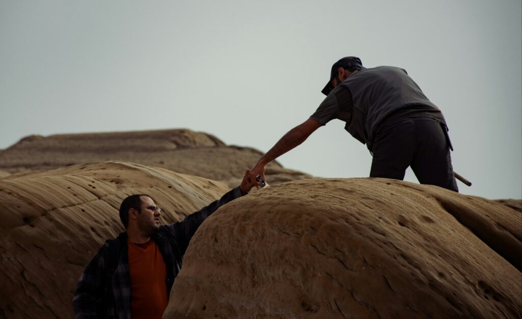 One man reaching out a hand to help another up