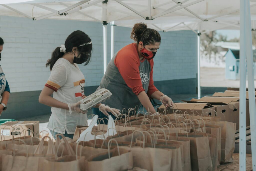 Volunteers packing food bags at an outdoor distribution