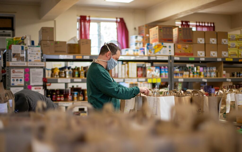 Woman stocking a community pantry shelf