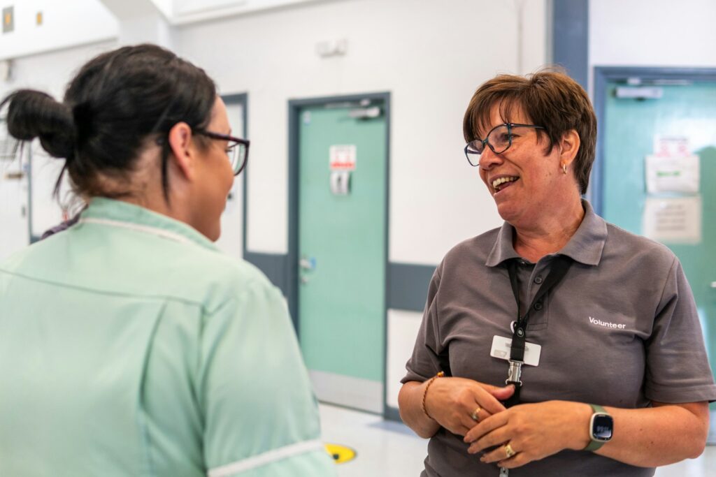 A support worker speaking with a woman in a hallway