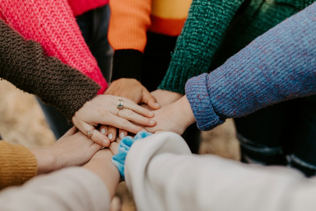 A group stacking hands together in unity